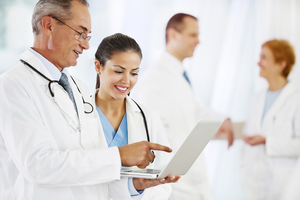 Two doctors looking at the laptop.